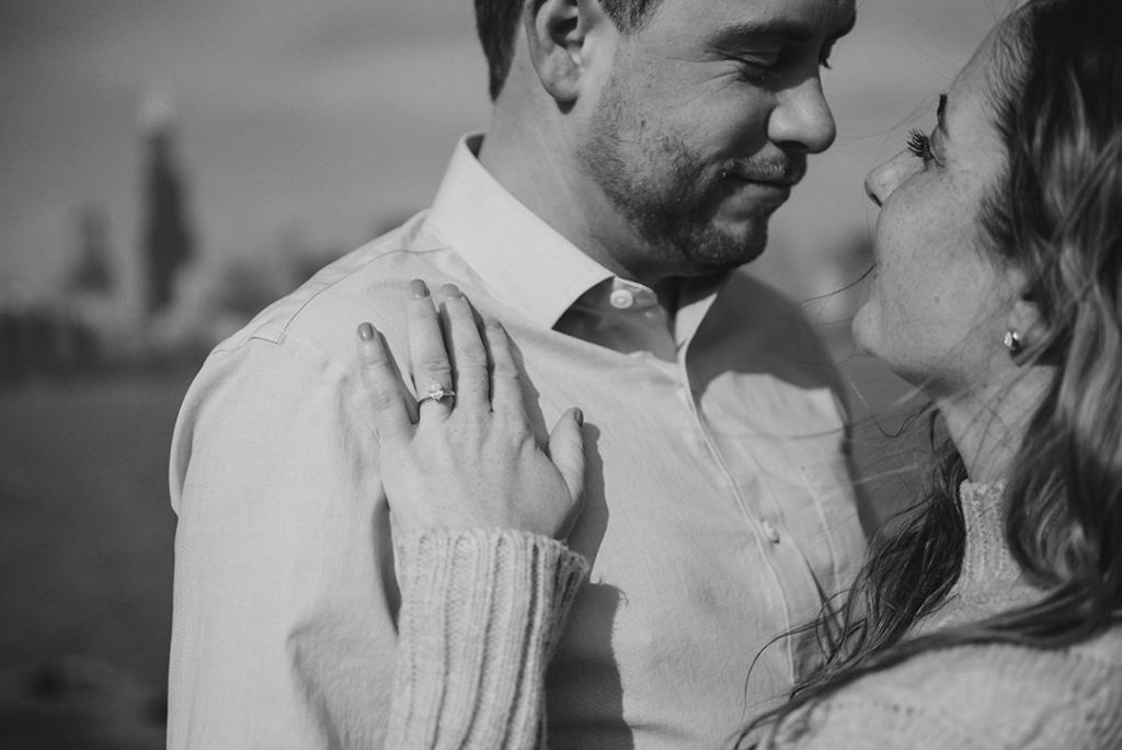 a woman's hand on her husbands chest with the sears tower in the distance