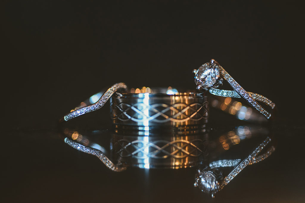 wedding rings reflecting off of a mirrored surface