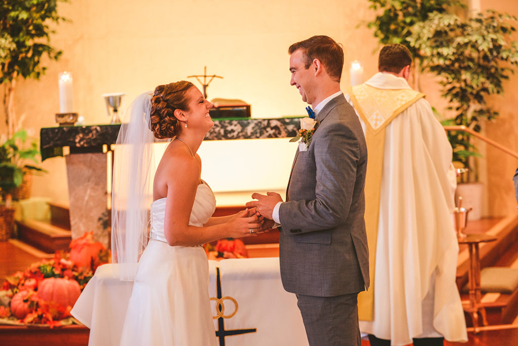 a bride and groom laughing after they put on their rings