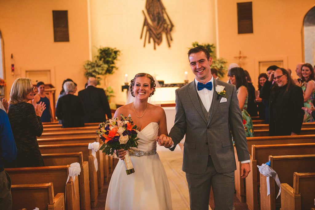 a newly married couple walking down a church aisle after just getting married