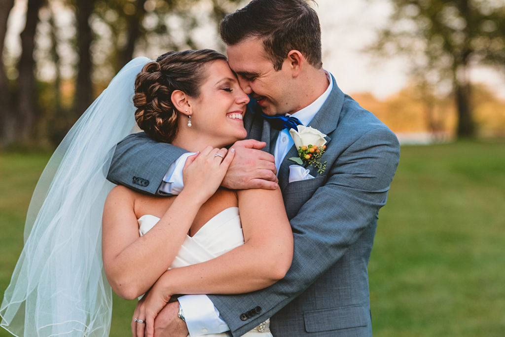 a bride and groom snuggling up in each others arms in the woods