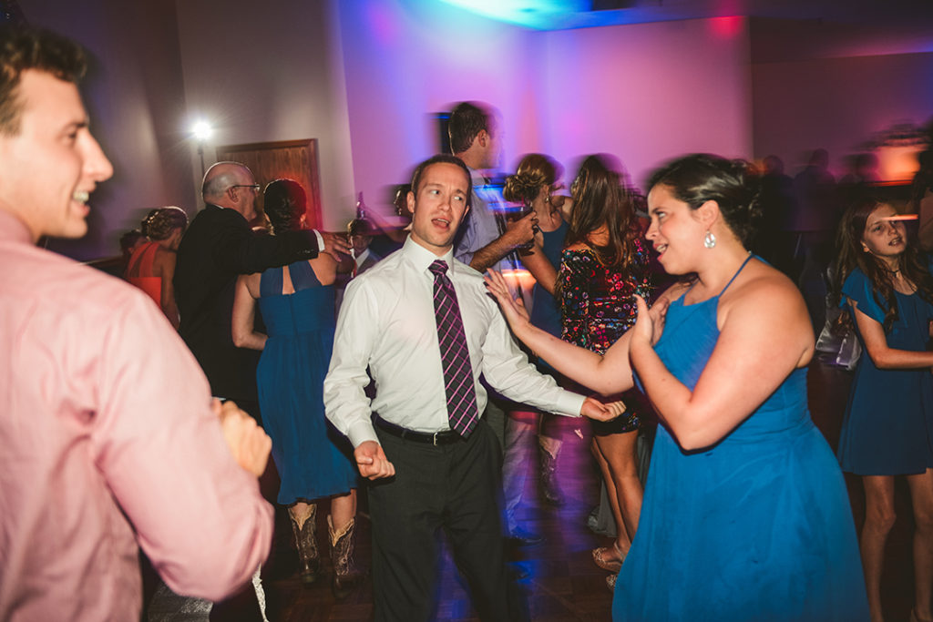 a couple at a wedding reception messing around on the dance floor