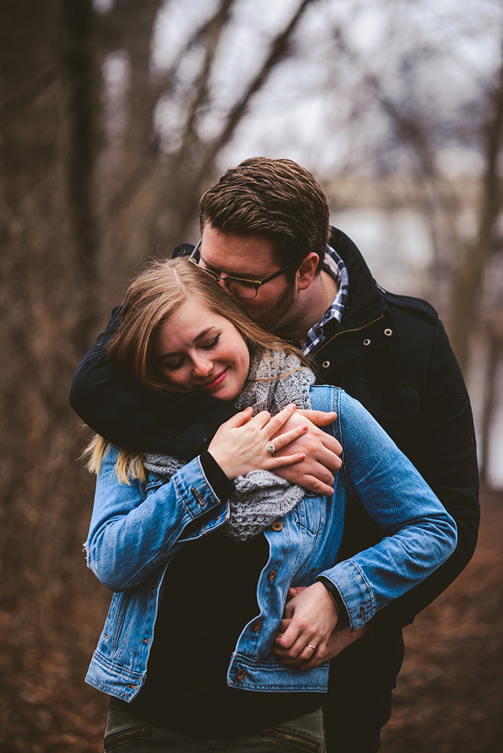 a married couple tangled in a hug as he kisses his wives neck