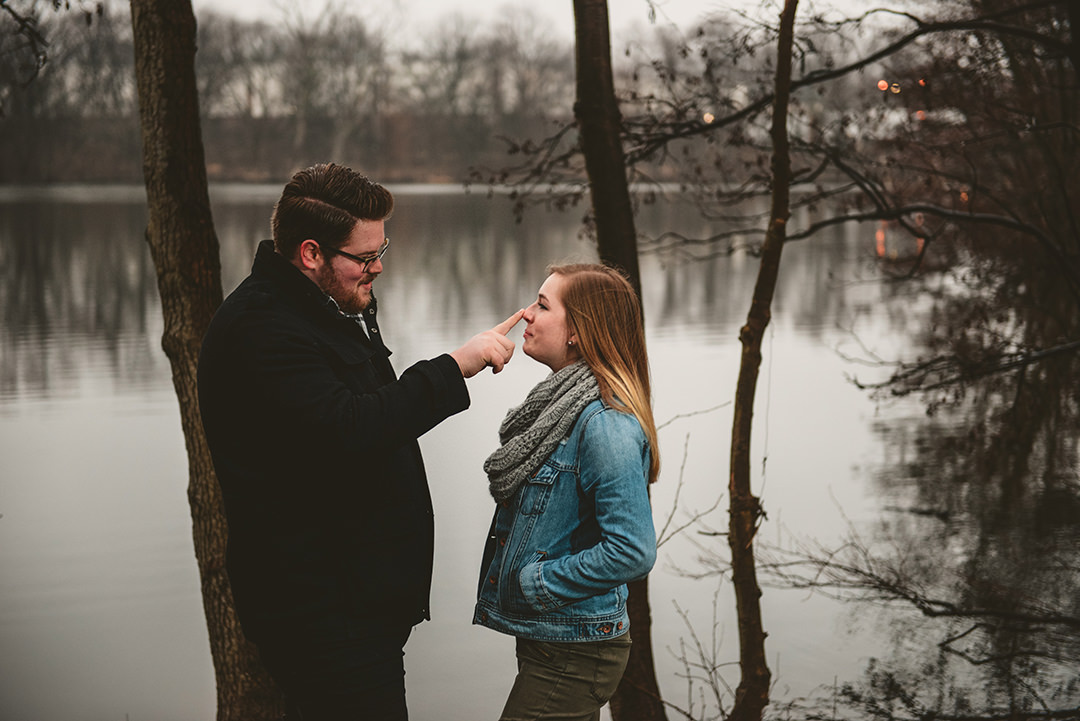 a man booping his brides nose in the woods