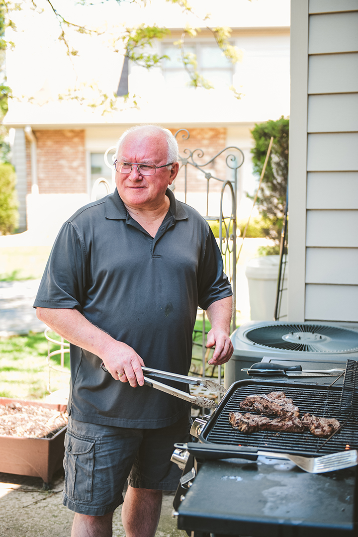 Father grilling at home on wedding day