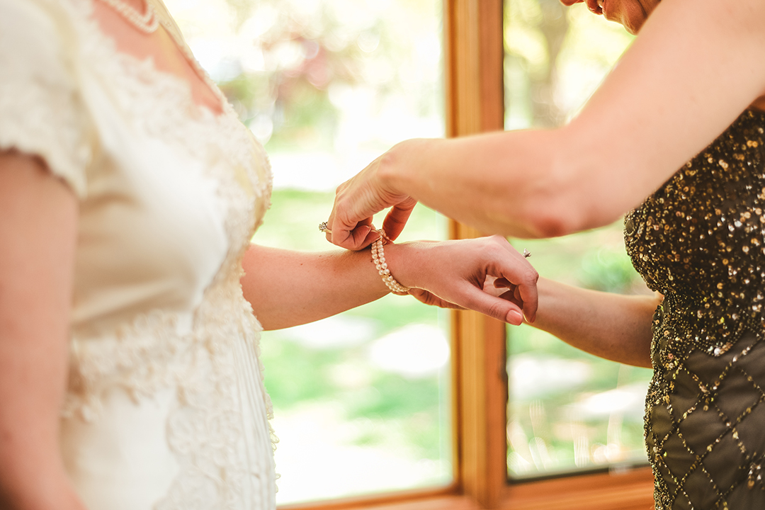 the brides mother putting on the brides bracelet