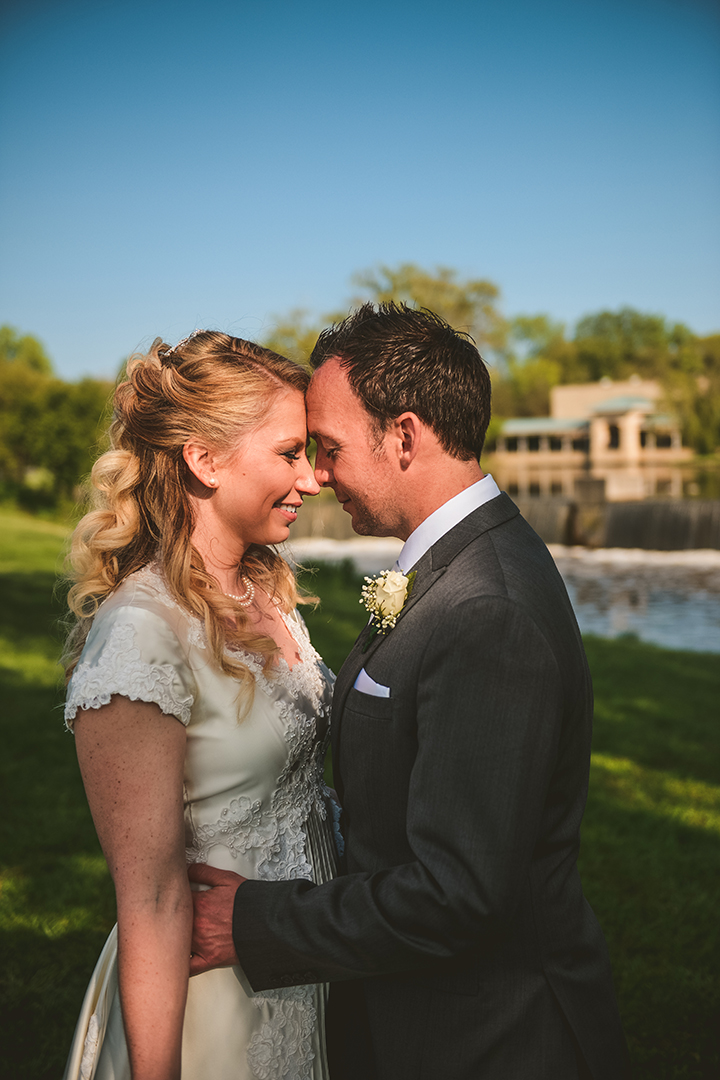 sunlight cascading against a bride and grooms faces as they kiss