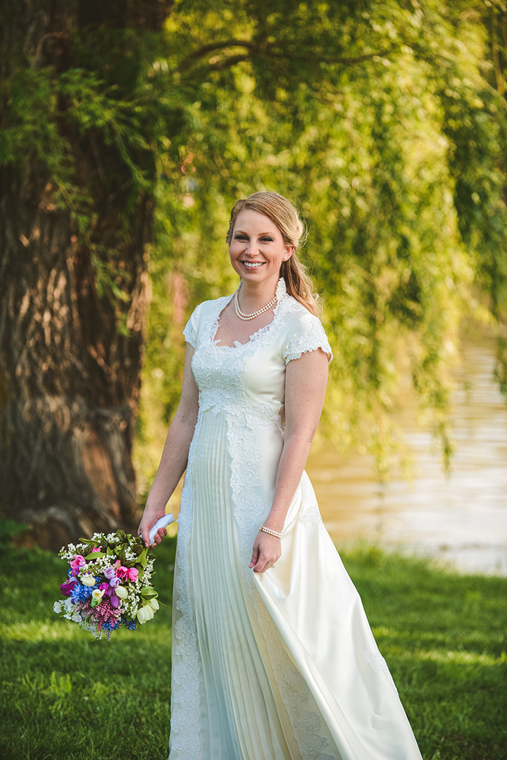 a bride playing with her dress at a park