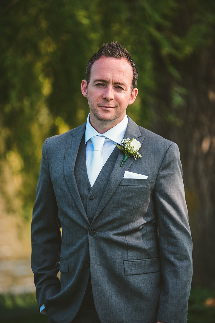 the groom with his hands in his pocket looking serious