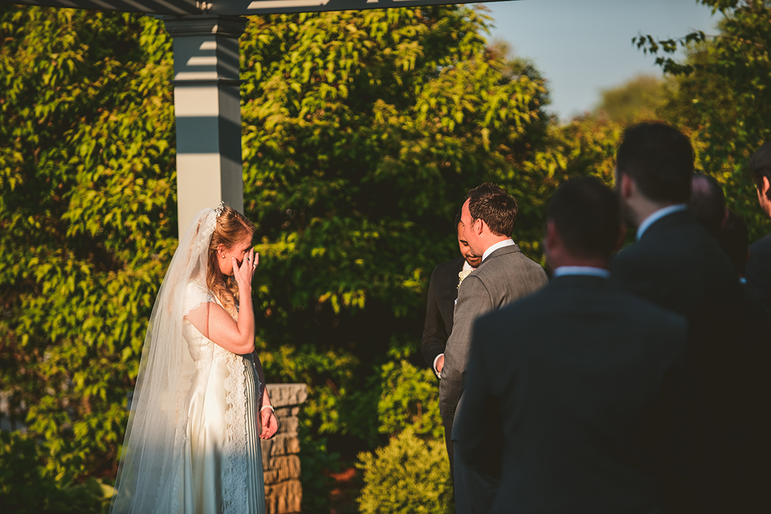 a bride brushing away a tear as she is getting married