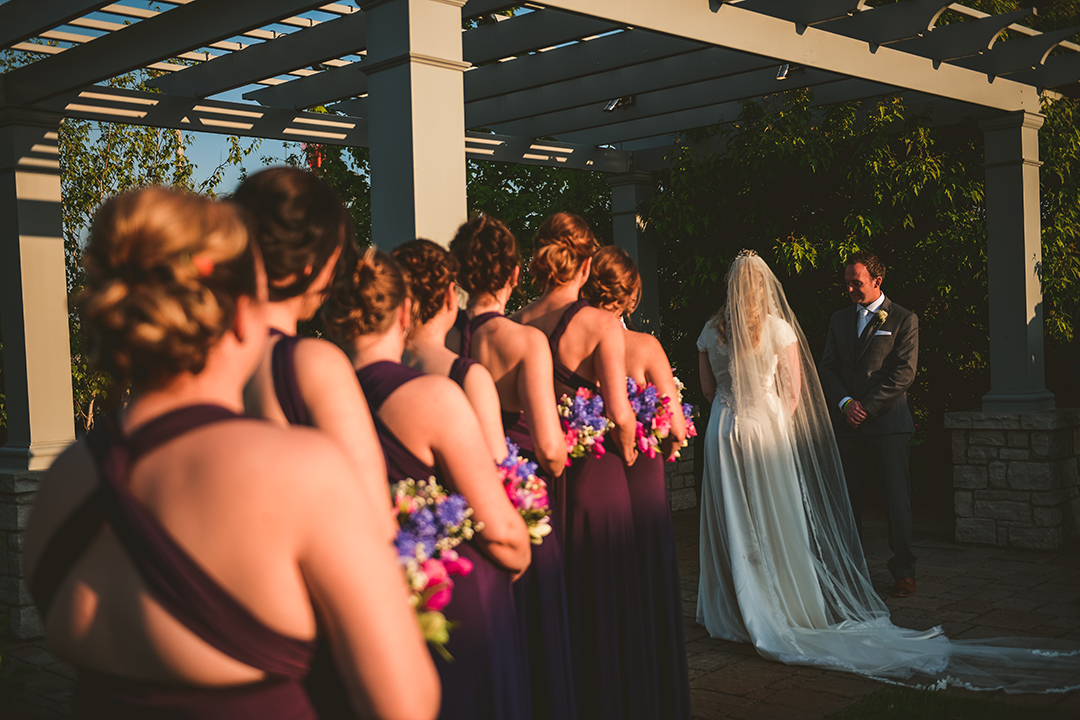 the bridesmaids watching the bride and groom getting married in the evening 