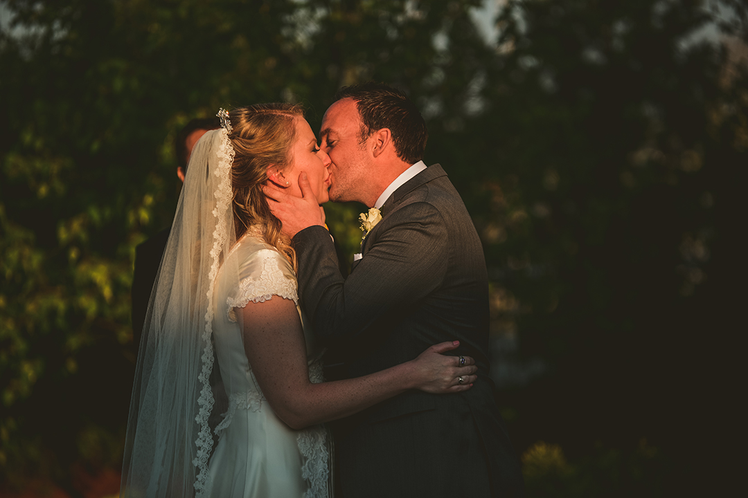 the bride and groom experiencing their first kiss during golden hour