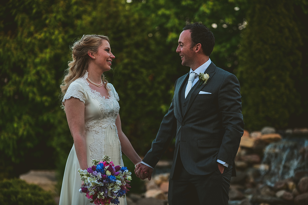 a man and a woman holding hands as they talk at a wedding