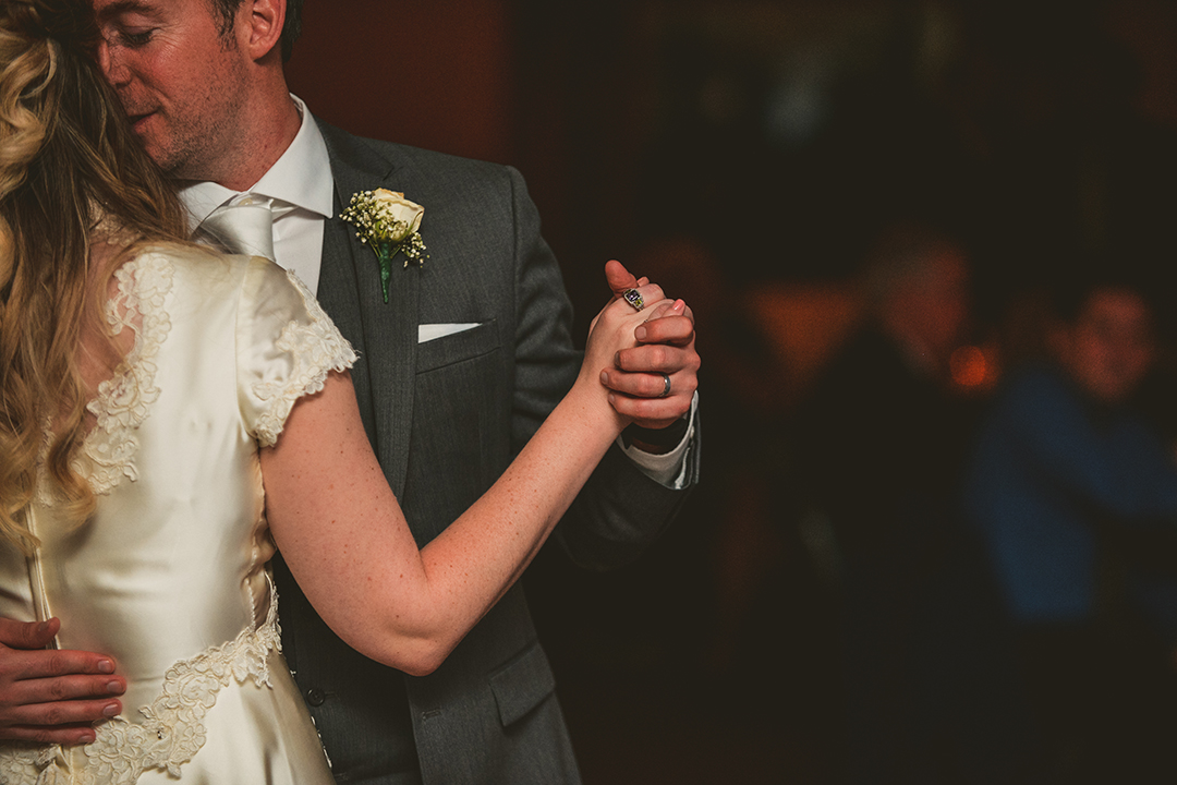 the bride and grooms hands as they dance during their first dance