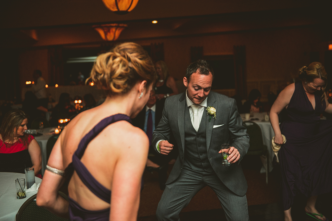 the groom dancing with a bridesmaid at his wedding reception