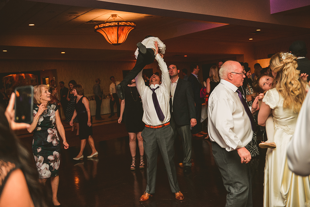 a man tossing a child into the air at a wedding reception