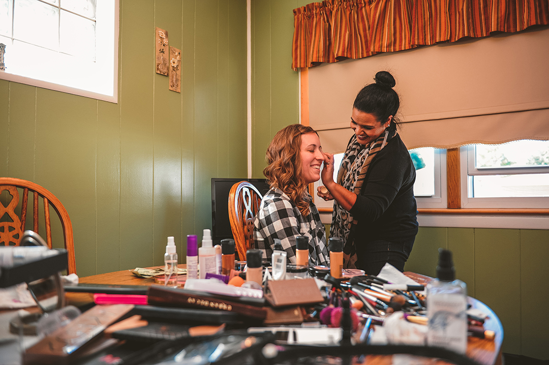 a bride getting her makeup done as she laughs at her Joliet home