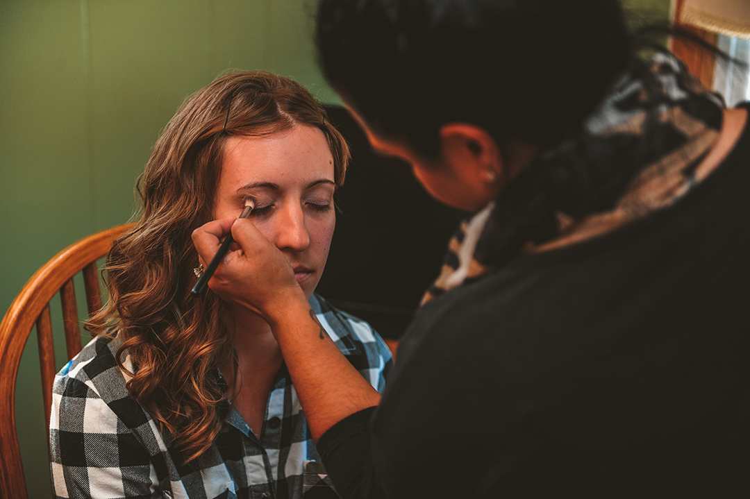 a makeup artist applying a brides makeup in Joliet