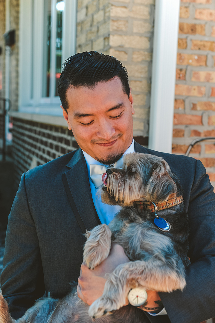 a groom holding his dog on his wedding day