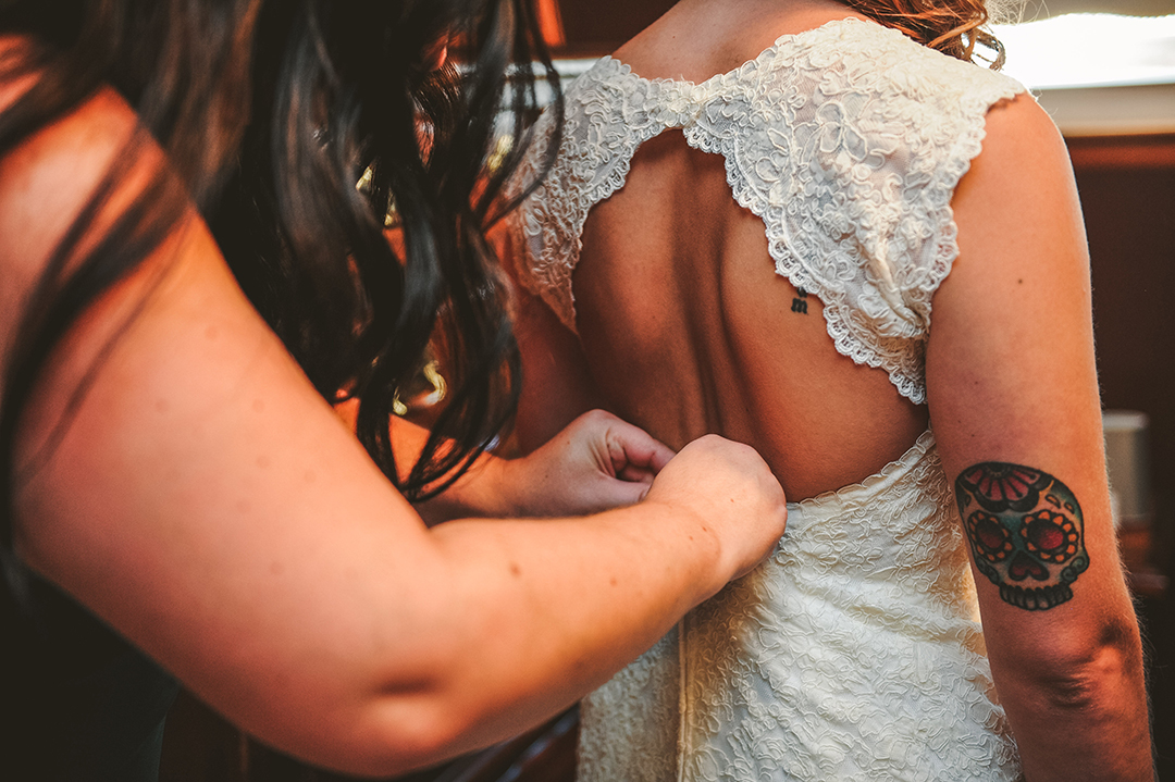 a bridesmaid zipping up a brides dress in Joliet