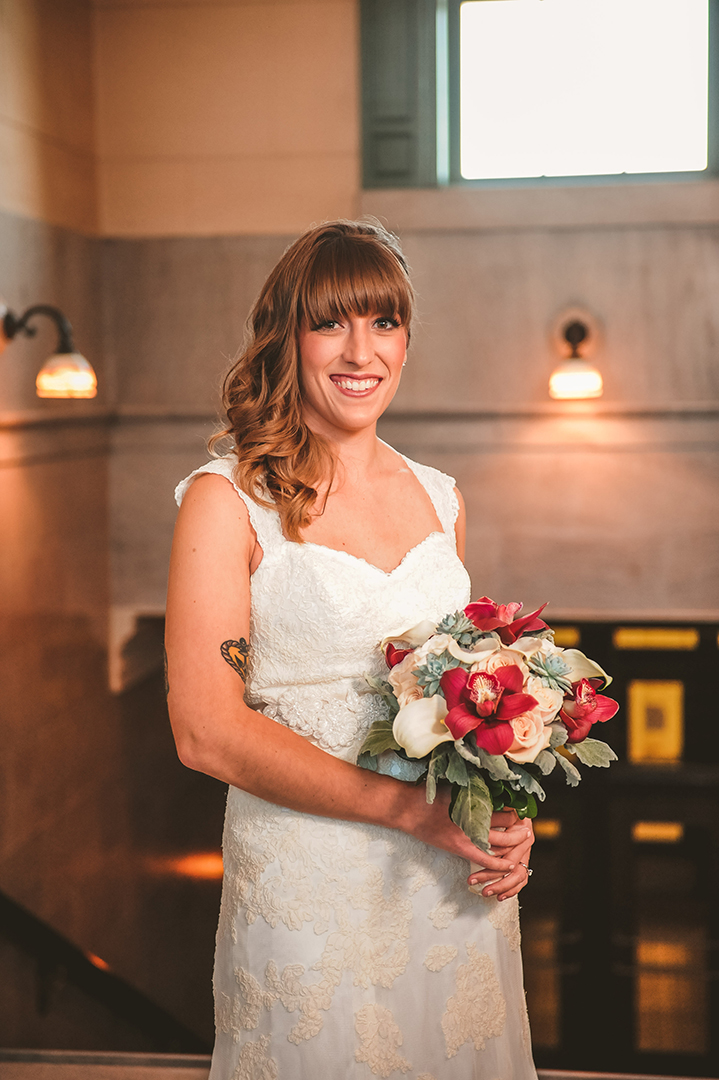 a smiling bride at the Joliet Union Station holding her bouquet