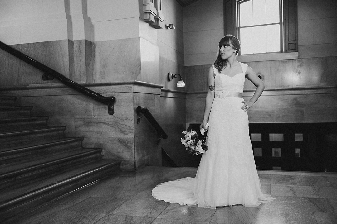 black and white image of a bride holding her flowers at the Joliet Union Station