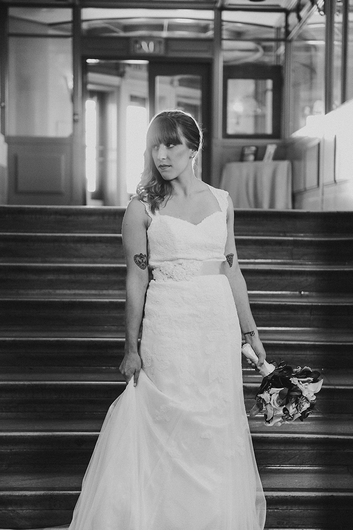 black and white image of a bride holding her dress at the Joliet Union Station