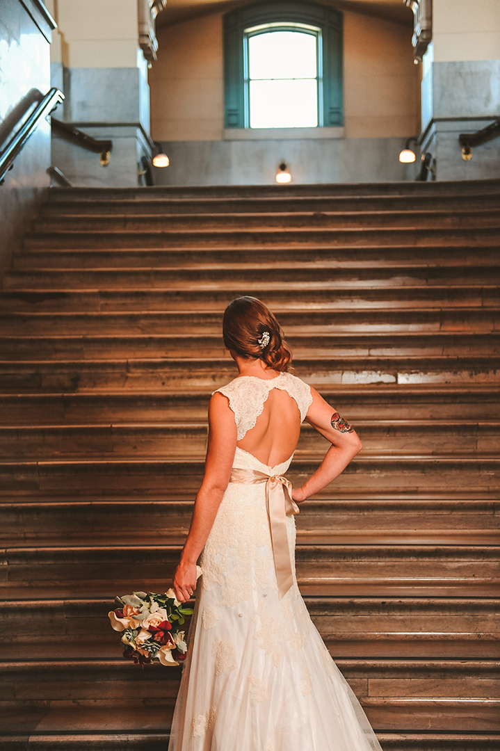 a bride with her hand on her hips at the Joliet Union Station with her flowers