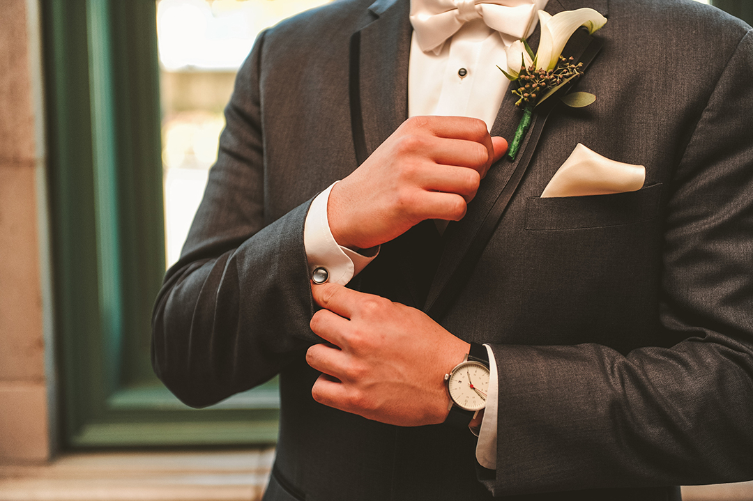 a groom adjusting his cuff links before getting married