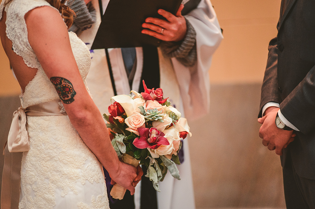 a tattooed bride holding onto her bouquet during her wedding day