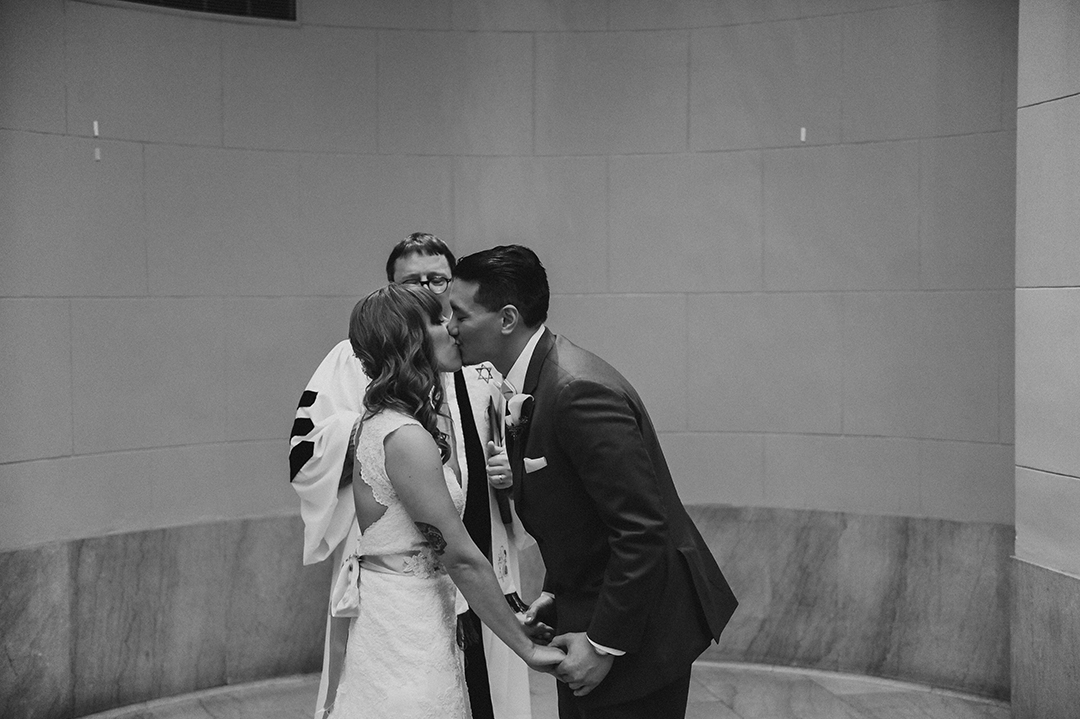 a bride and groom kissing for the first time as husband and wife