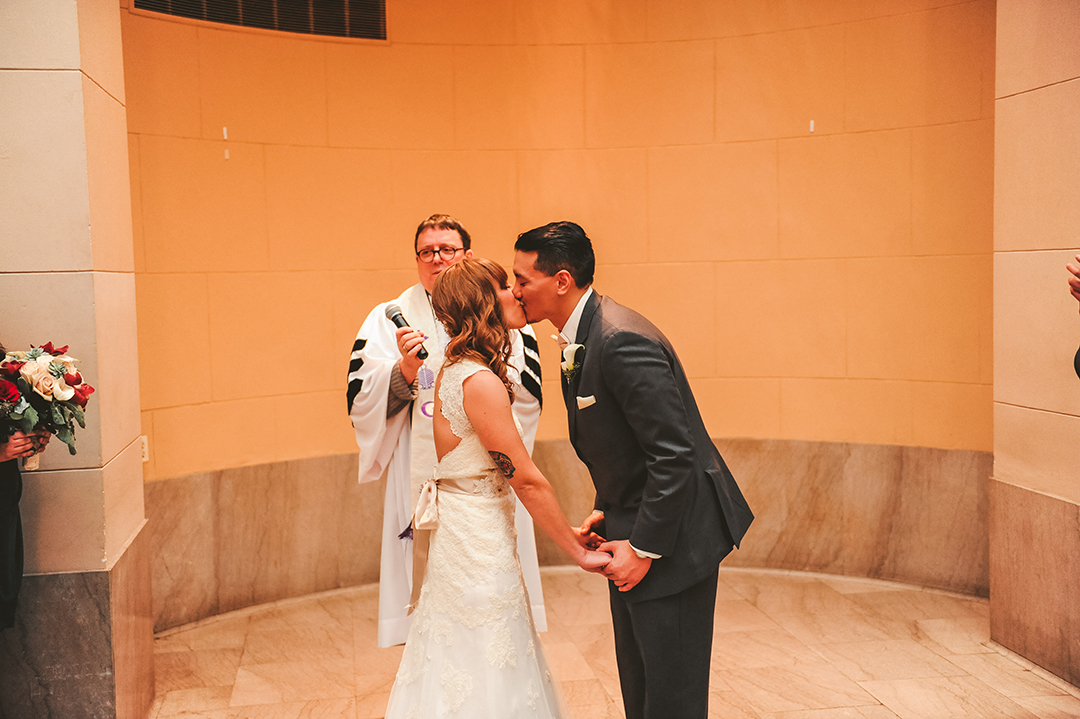 a bride and groom kissing for the first time at their wedding