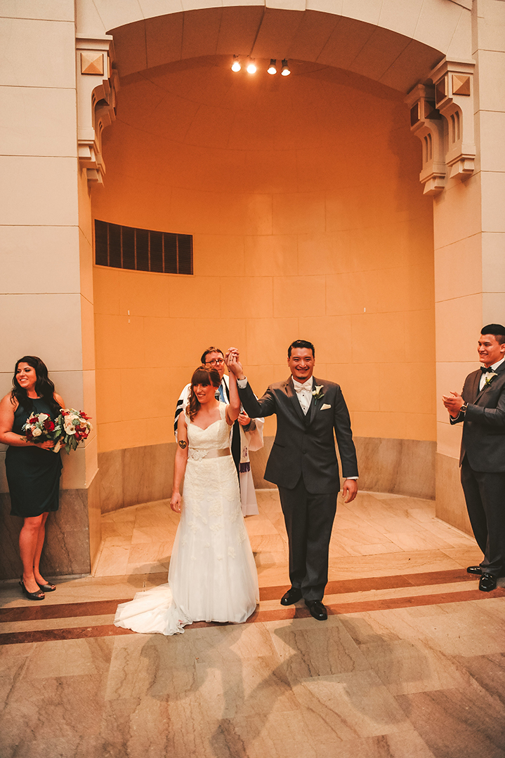 a bride and groom celebrating after their wedding ceremony