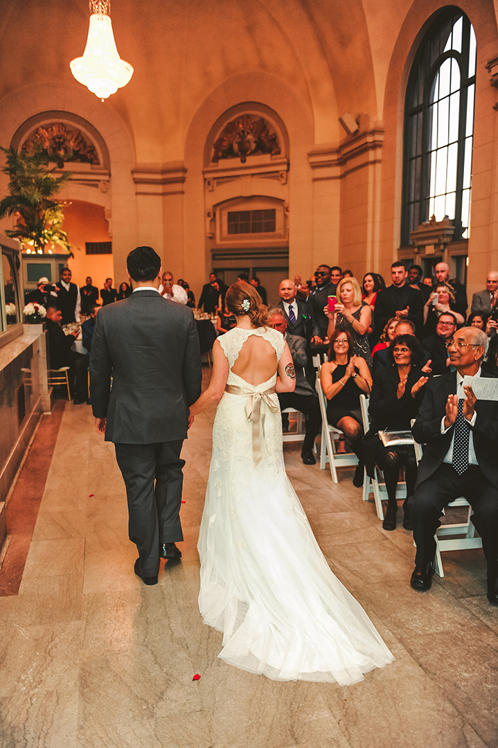 a bride and groom walking down the aisle at the Joliet Union Station