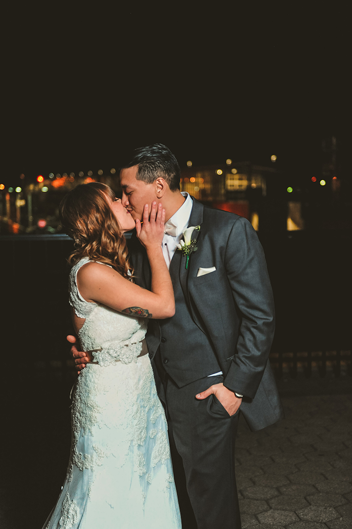 a husband and wife kissing at night in downtown Joliet