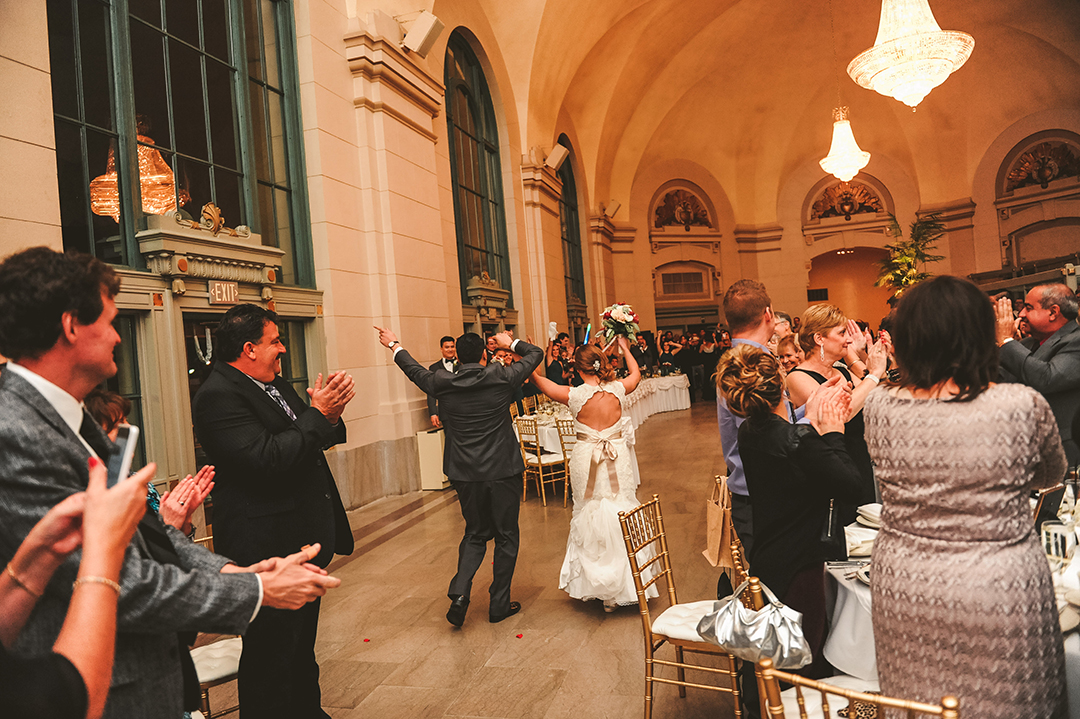 a bride and groom dancing as they enter their wedding reception