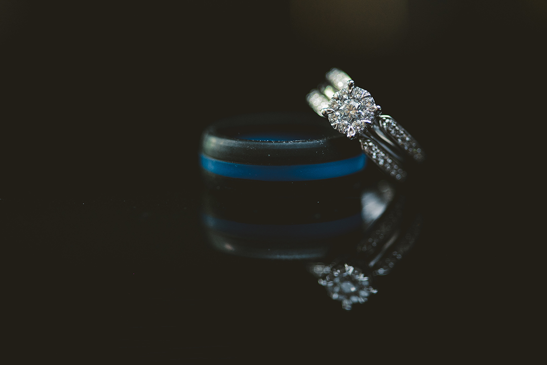 wedding rings reflecting on a mirrored black surface