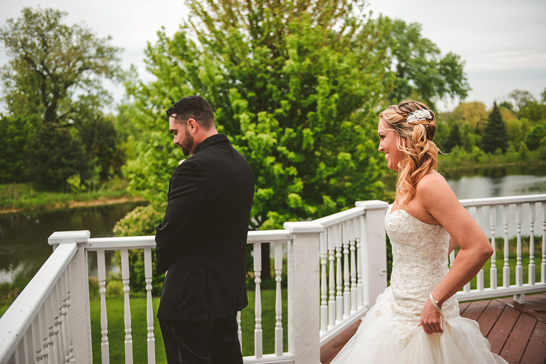 a bride walking up behind her groom for their first look