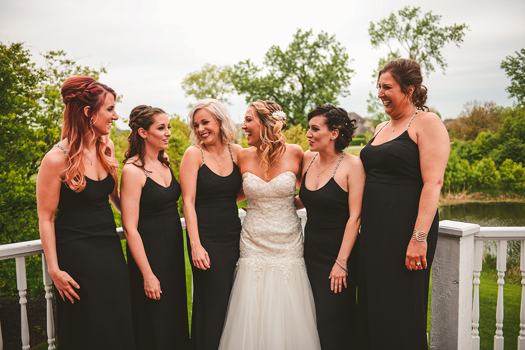 bridesmaids standing around while laughing in their beautiful dresses