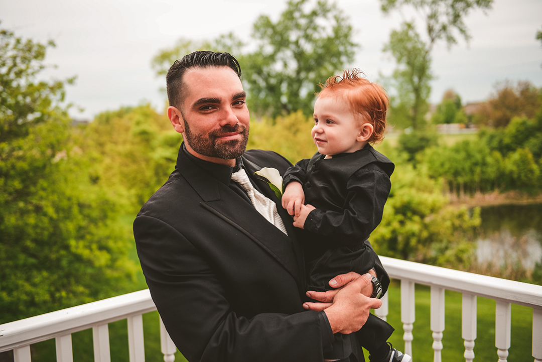 a groom holding onto his son on his wedding day