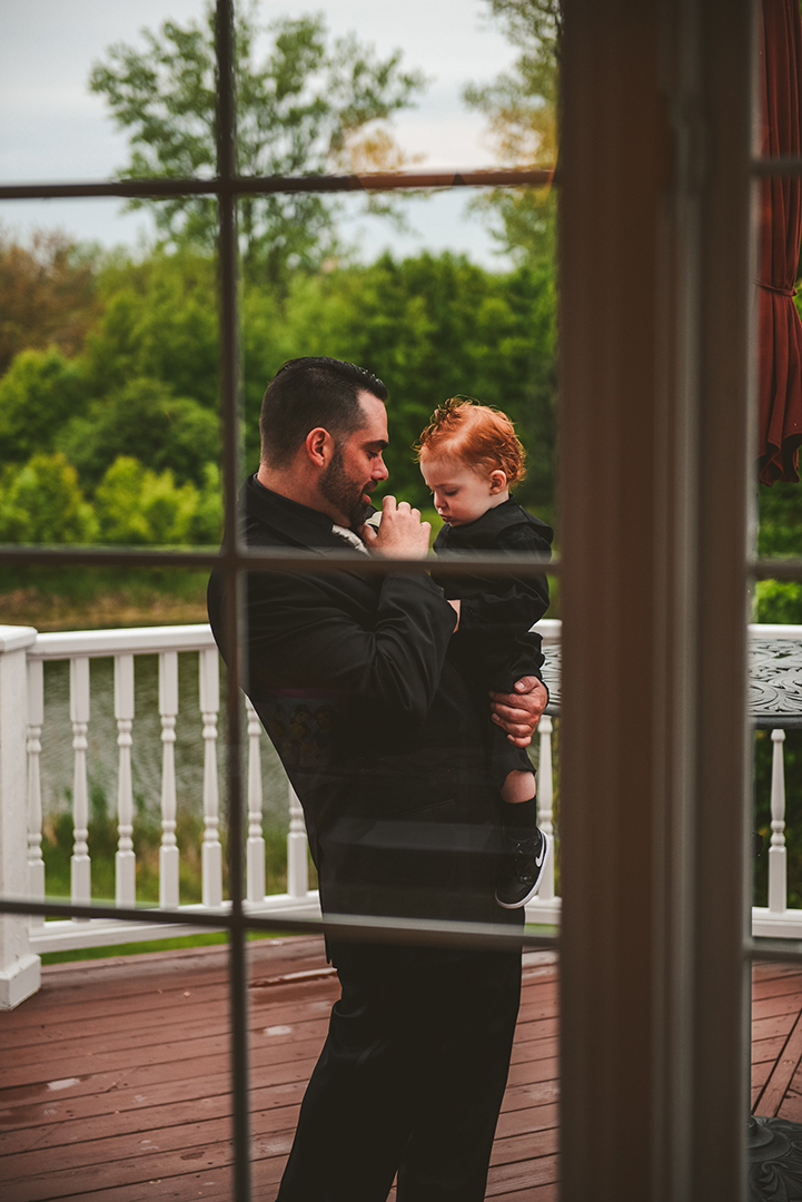 through a window of a groom holding his son