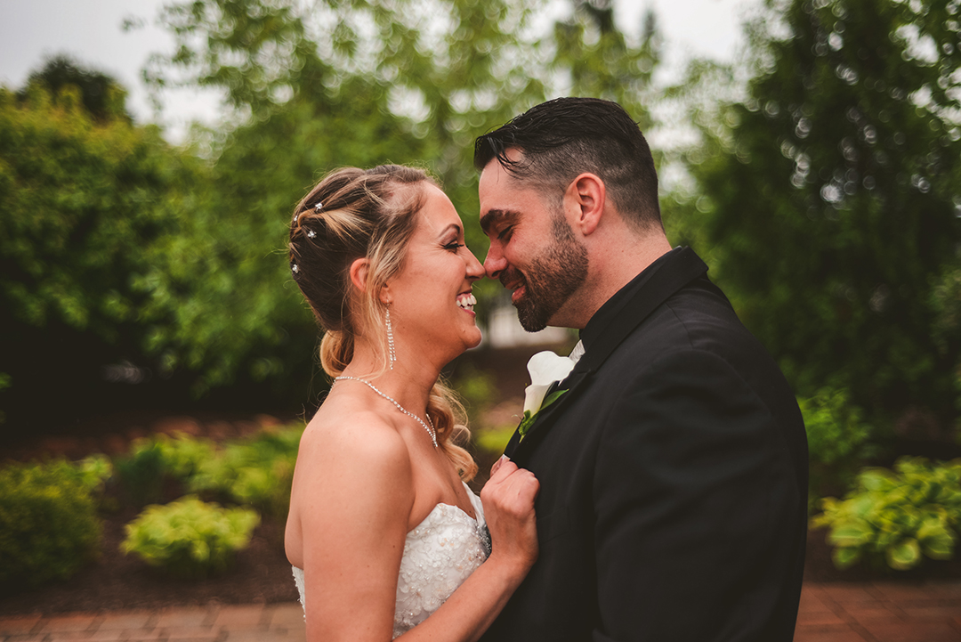 a man and a woman about to kiss outside on their wedding day