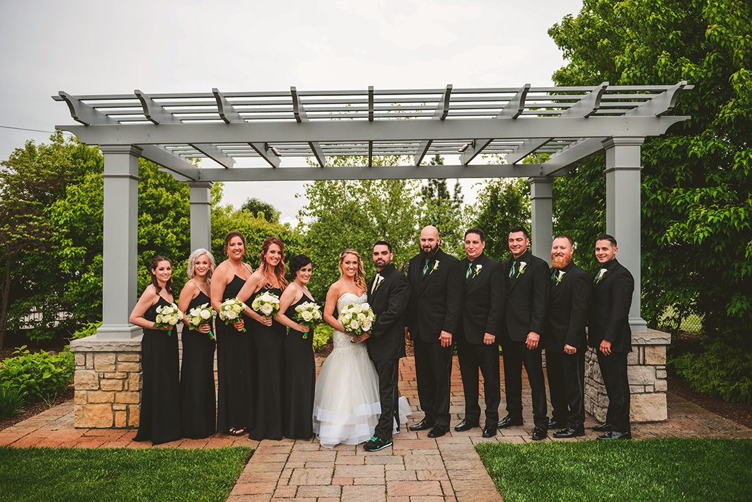 a bridal party standing under a pergola in Oak Forest