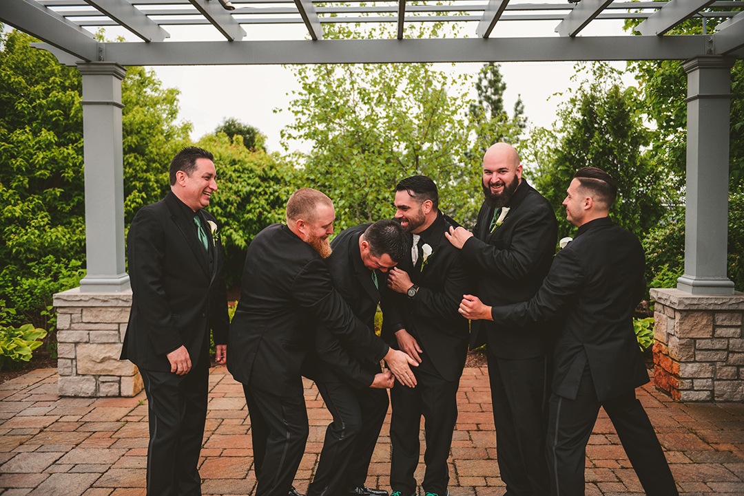 the groomsmen giving the groom a hard time on his wedding day