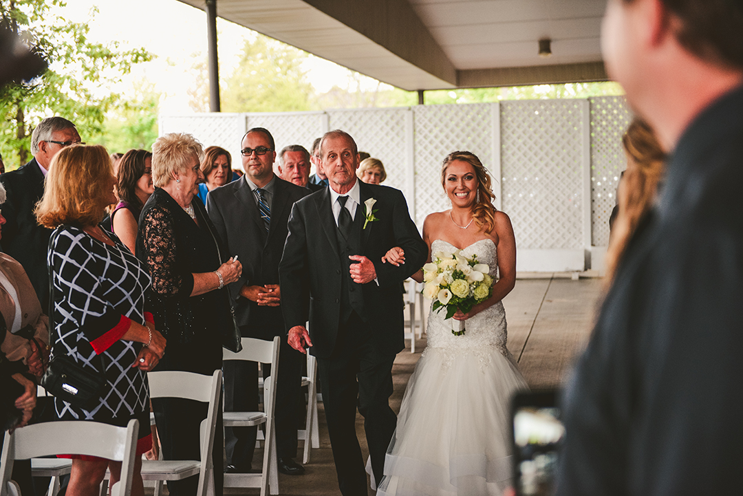 A brid and her father walking down the aisle with everyone watching