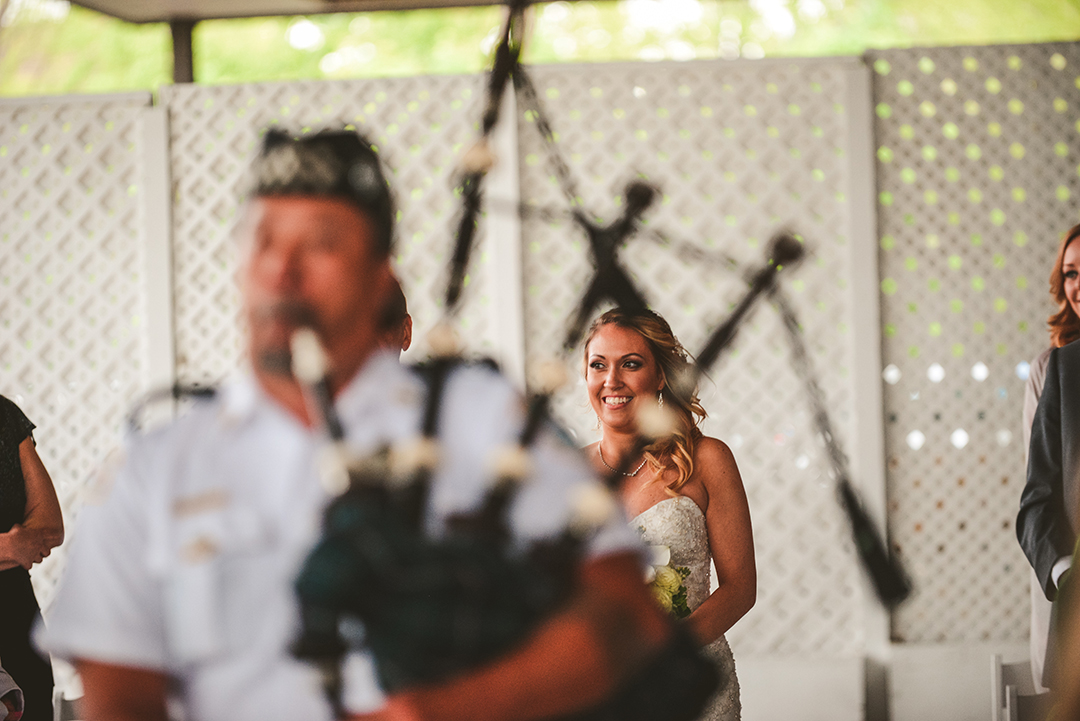 a bagpiper walking down the aisle with the bride in the background