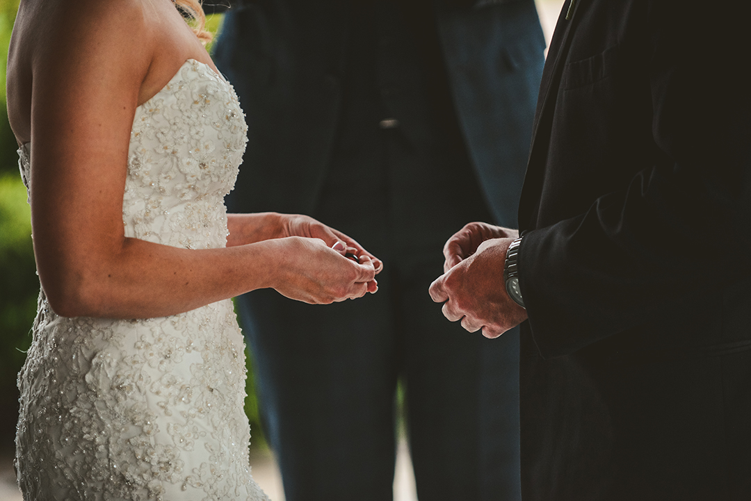 the bride and groom holding their rings during their wedding ceremony