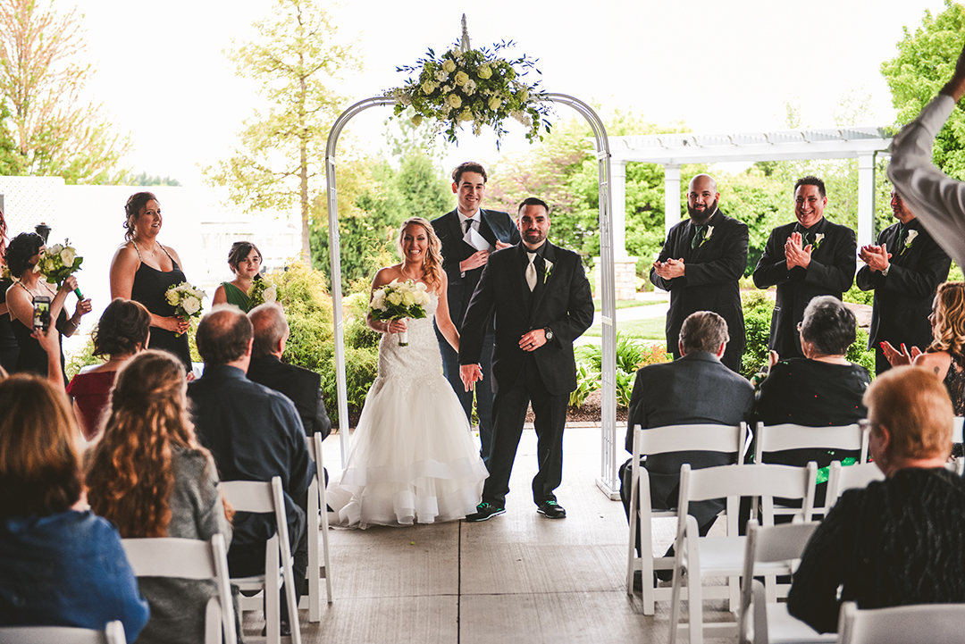 the bride and groom coming down the aisle after their wedding