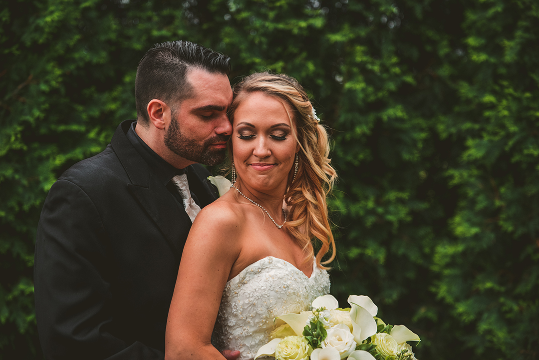 the groom behind his wife as she looks back at him