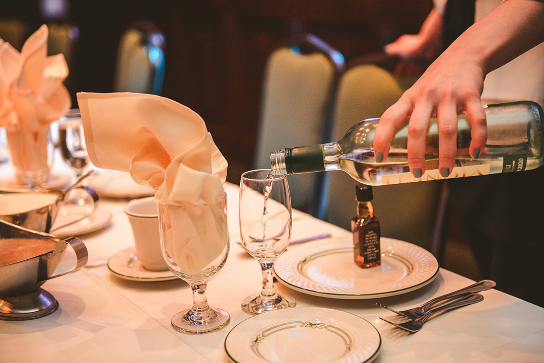 a server pouring wine at a wedding ceremony